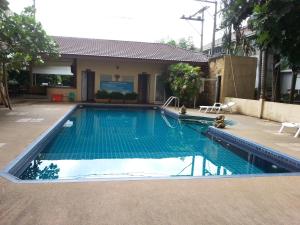a swimming pool with blue water in front of a house at C.A.P Mansion in Phuket