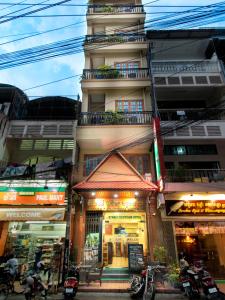 a building with shops and motorcycles in front of it at Dynsey Boutique Hotel in Phnom Penh