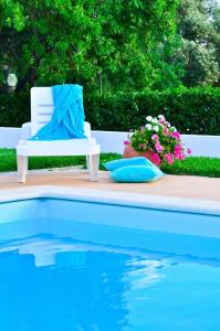 a white chair sitting next to a swimming pool at Quinta das Amendoeiras in Albufeira
