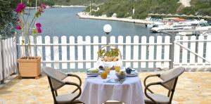 a table with a plate of food on top of a white fence at Paxos Bay Studios in Gaios