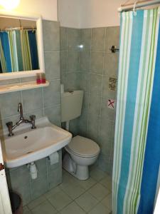 a bathroom with a toilet and a sink at Poseidon Hotel in Heraklio