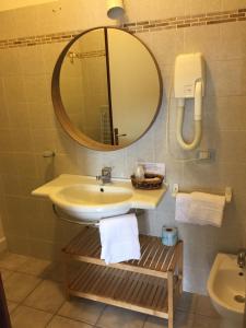 a bathroom with a sink and a mirror and a toilet at Hotel Le Palme in Albinia