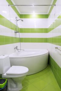 baño verde y blanco con bañera y aseo en Apartments in Old City, en Kamianets-Podilskyi