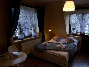 コシチェリスコにあるTatra Slow Pokoje i Apartamentyのベッドルーム1室(ベッド1台、テーブル、窓付)
