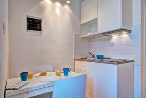 a kitchen with a table with a plate of food at Apartman Amfiteatar Franko in Pula