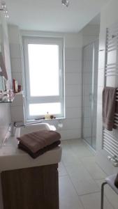 クックスハーフェンにあるResidenz Windjammerの窓、洗面台、シャワー付きのバスルームが備わります。