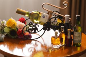 a table with bottles of wine and flowers on it at New Space Hotel Airport in Ho Chi Minh City