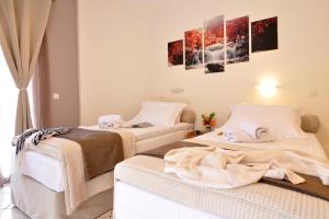 two beds in a room with paintings on the wall at Rolandos Apartments in Agios Gordios