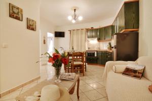a living room with a vase of flowers on a table at Rolandos Apartments in Agios Gordios +17 photos