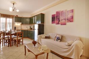 a kitchen and a living room with a couch and a table at Rolandos Apartments in Agios Gordios