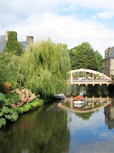 a bridge over a river with a boat in the water at Le studio Florent in Lannion
