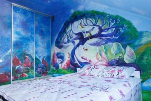 カームヤネツィ・ポジーリシクィイにあるApartments in Old Cityのベッドルーム1室(壁に絵画が描かれたベッド1台付)