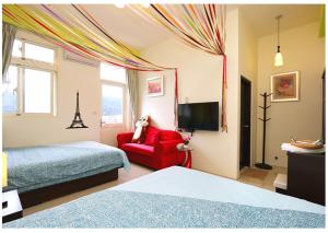 Habitación de hotel con cama y silla roja en Hong Lai Guest House, en Jiaoxi
