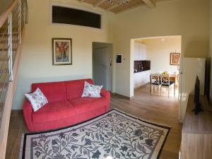 a living room with a red couch and a kitchen at Il balcone di Rina in San Gimignano