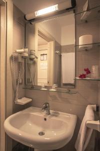 a bathroom with a sink and a mirror at Eden Beach Club in Torre Canne