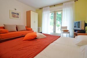 ein Schlafzimmer mit einem großen Bett mit einer orangefarbenen Decke in der Unterkunft Apartment Rojnic in Pula