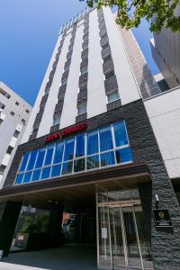 um edifício alto com um sinal em cima em Hotel Gran Cerezo Kagoshima em Kagoshima