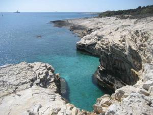 a group of rocks in the water near the ocean at Apartman Amfiteatar Franko in Pula