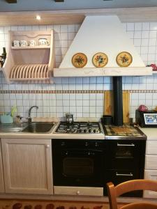 een keuken met een fornuis en een wastafel bij Ciasa Cimoliana in Cimolais