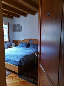 - une chambre avec un lit et une porte en bois dans l'établissement Ciasa Cimoliana, à Cimolais