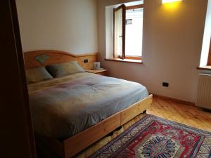 - une chambre avec un lit en bois et une fenêtre dans l'établissement Ciasa Cimoliana, à Cimolais