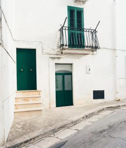 チェーリエ・メッサーピカにあるCasa Turcheseの白い建物に緑のドア2つ、バルコニー付