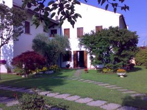 a white house with a green yard with a pathway at Alle Grazie in Casièr