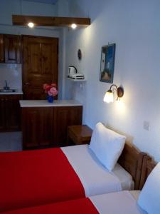 a hotel room with a couch, coffee table and a television at Sofia's Garden Studios in Skopelos Town