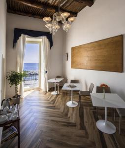 a room with tables and chairs and a large window at Mareluna Suite de Charme in Naples