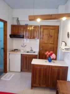 a kitchen with a sink, stove, and refrigerator at Sofia's Garden Studios in Skopelos Town
