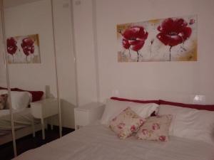a bedroom with a bed with red flowers on the wall at Alle Grazie in Casièr
