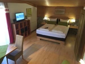 a bedroom with a bed and a table and a television at Landhaus Taxach in Saalbach Hinterglemm
