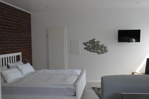 ブルク・アウフ・フェーマルンにあるDas kleine Stadtapartmentの白いベッドとレンガの壁が備わるベッドルーム1室が備わります。