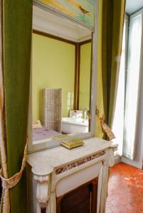 a mirror sitting on top of a vanity in a bathroom at La Petite Saunerie in Avignon +27 photos