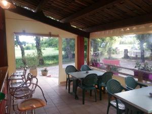 un restaurant avec des tables et des chaises et une terrasse dans l'établissement Camping Parc Saint Sauvayre, à Vagnas