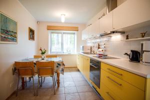 a kitchen with yellow cabinets and a table and chairs at Tiigi Villa in Haapsalu