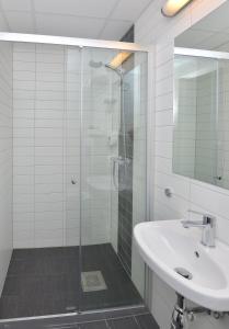a bathroom with a glass shower and a sink at Thon Partner Hotel Andrikken in Andenes