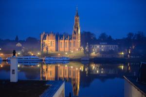 a building with a clock tower next to a body of water at Ringelnatz Inselhotel in Malchow