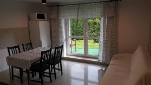 a living room with a table and chairs and a window at Agroturystyka Bliźniaczek in Rymanów-Zdrój