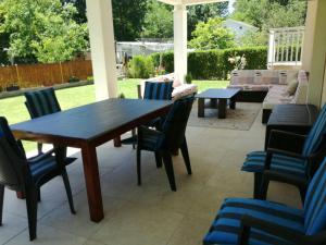 a patio with a wooden table and chairs at Riverside Guesthouse in Počitelj