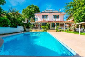 a large swimming pool in front of a house at Calypso Cozy Suites in Dalyan