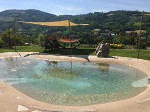 a pool of water in a yard with a tent at Locanda Montelippo in Colbordolo