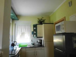 a kitchen with a refrigerator and a window at Bungalow Idylle Am See in Neuruppin