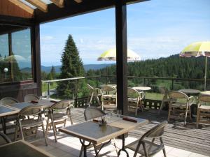 un restaurant avec des tables et des chaises sur une terrasse dans l'établissement Les Terrasses du Lac Blanc - Studios & Appartements, à Orbey