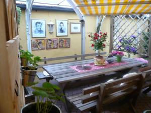 um pátio com uma mesa de madeira e algumas plantas em Stadtschenke em Villach