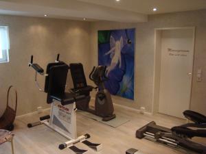 una habitación con un gimnasio con equipamiento de ejercicio y una pintura en Bella Casa en Langenargen