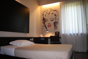 - une chambre avec un lit orné d'une peinture murale dans l'établissement Art Hotel Udine, à Udine