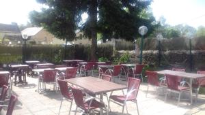 a group of tables and chairs in a patio at Auberge Du Bon Coin in Moulins-Engilbert +1 photo
