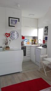 a kitchen with white cabinets and a red rug at Apartment Jovana Krunska in Belgrade