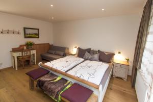 a bedroom with a bed and a couch at Hotel Alpenblick in Riedering